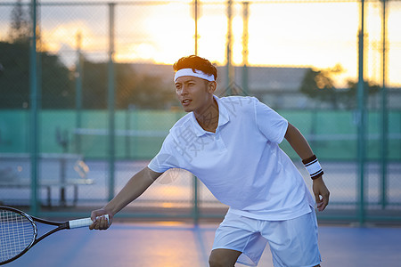 日落网球俱乐部打网球的青年男性图片