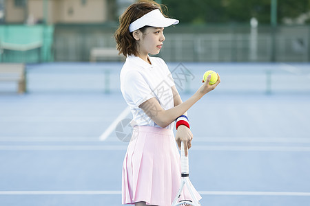 网球场上穿着运动装拿着网球的女孩图片