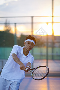户外网球场穿着运动装打网球的男性图片