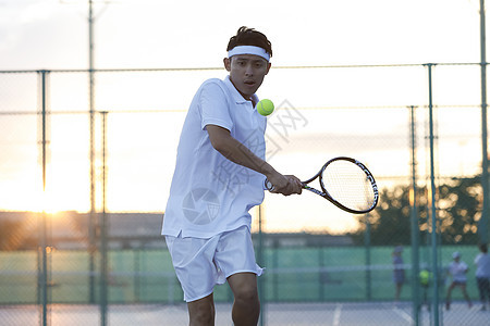 户外网球场穿着运动装打网球的职业选手图片