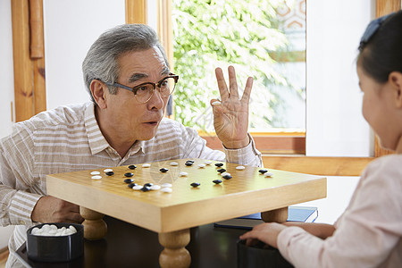 爷爷陪伴孙女下围棋图片