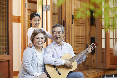 祖孙三人坐在门口弹吉他图片