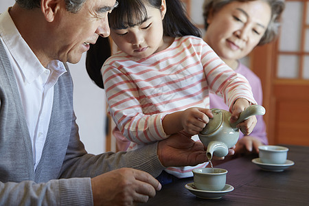 幸福的老年夫妇和孙女喝茶图片