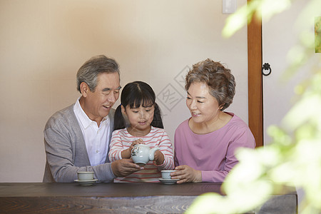 幸福的老年夫妇和孙女喝茶图片