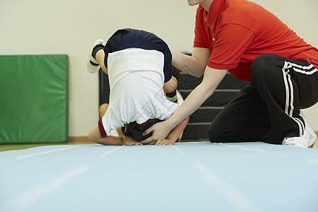 老师的帮助下在垫子上锻炼的小朋友图片
