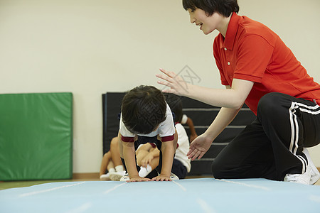 指导小孩在垫子上练习的老师图片