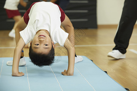 小男孩在垫子上练习锻炼图片