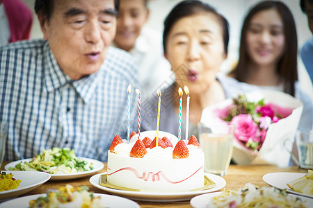 餐桌上点上蜡烛的蛋糕图片