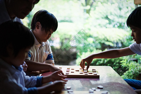 职业男击中一个学习将棋的男孩图片