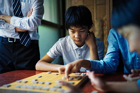 看着棋盘沉思的小男孩图片