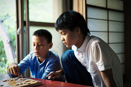 看着棋盘思考的小男孩图片