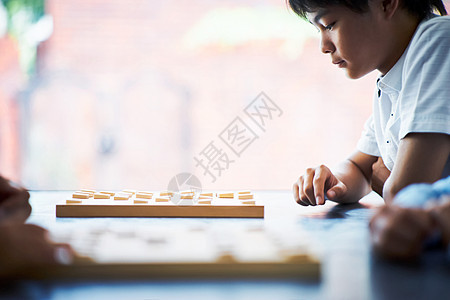 看着棋盘思考的男孩图片