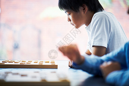 看着棋盘思考的男孩图片