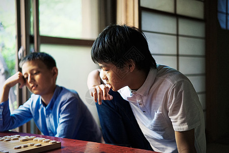 看着棋盘思考的小男孩图片