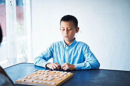 看着棋盘的小男孩图片