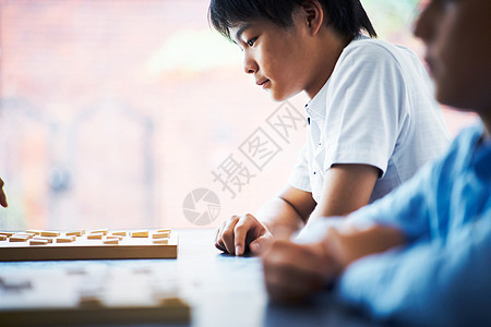 看着棋盘思考的小男孩图片