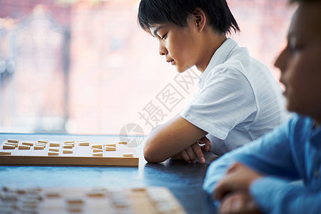 看着棋盘思考的孩子图片