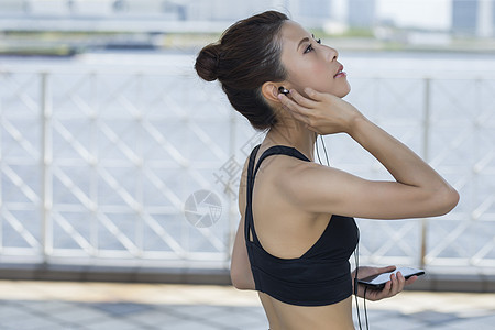 戴着耳机听音乐的年轻女性图片