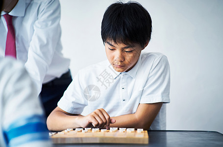 看着棋盘苦恼的小男孩图片