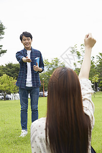 草坪上的男生和女生在讨论作业图片