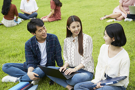 学生们围坐在草地上分享交流图片