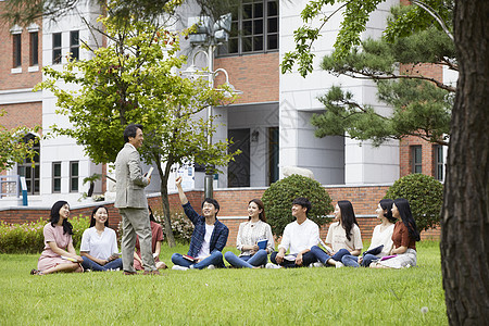 大学教授和学生们围坐在草地上分享交流图片