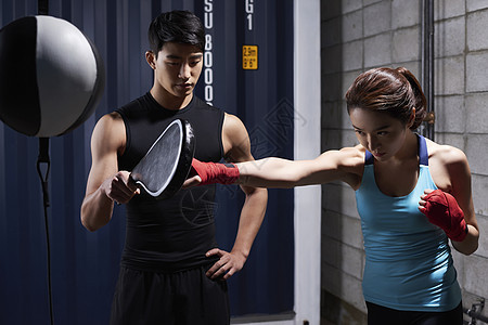 教练训练年轻女子拳击健身图片