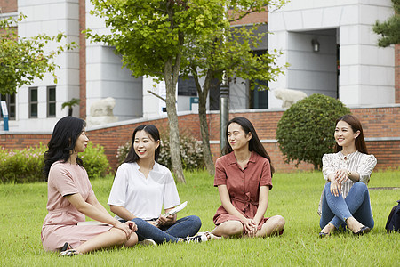 坐在草坪上休息的女大学生图片