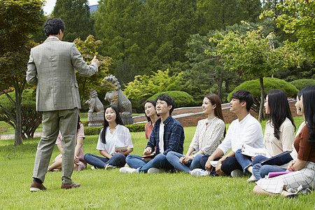 校园草坪上的青年大学生和教授图片