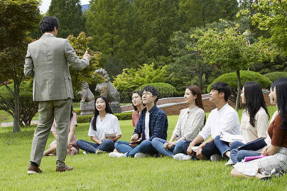 校园草坪上的青年大学生和教授图片