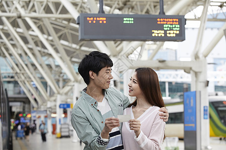 火车站拿着车票微笑的情侣图片