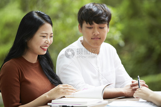 翻开书本微笑的年轻女性图片