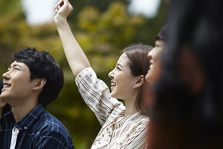 微笑举手的女大学生图片