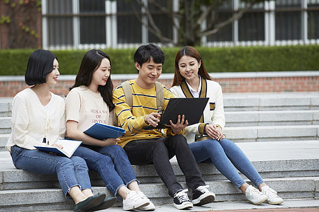 台阶上看着电脑的大学生图片