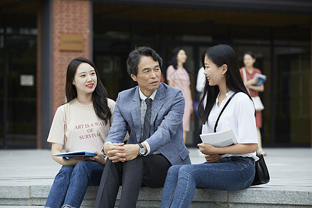 校园里和教授聊天的女大学生图片素材