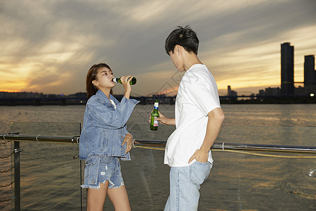 年轻男女江边喝酒图片素材