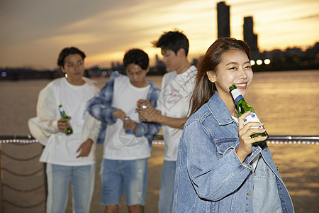 年轻男女江边喝酒图片素材