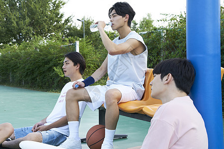 年轻人一起打篮球休息喝水图片