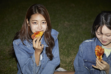 年轻女子在吃比萨饼图片