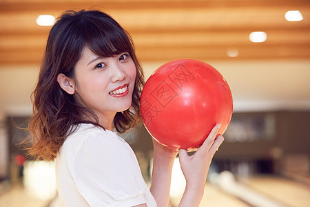 拿着保龄球转头微笑的女大学生图片素材