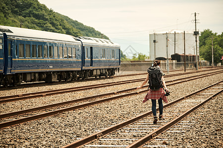 走在铁路轨道上的背包客背影图片素材