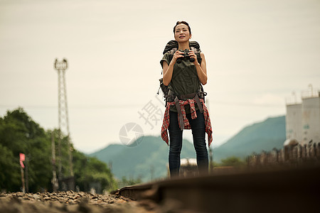 背包客女生在废弃铁路上旅游观光图片