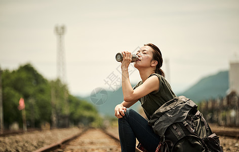 在废弃铁道上喝水的旅行者图片