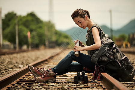 年轻女人在铁轨边休息
图片