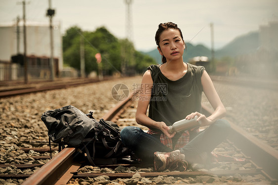 废弃铁轨前的年轻女子图片