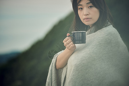 草原帅打碎妇女放松由湖的背包徒步旅行者画象图片