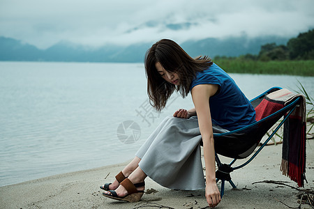 学生年轻人物放松在湖的女背包徒步旅行者图片