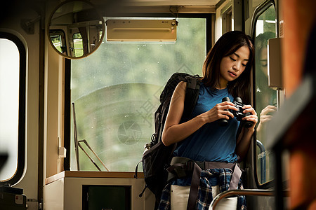 人类30多岁站立火车的女背包徒步旅行者图片