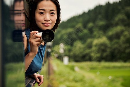 拿着相机的年轻女性图片