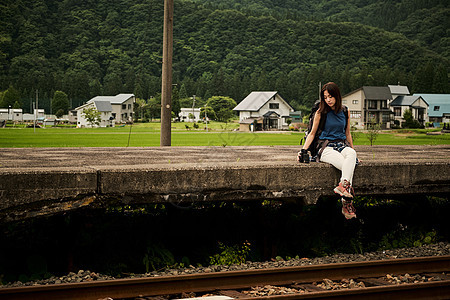 坐在火车站台的年轻女性图片
